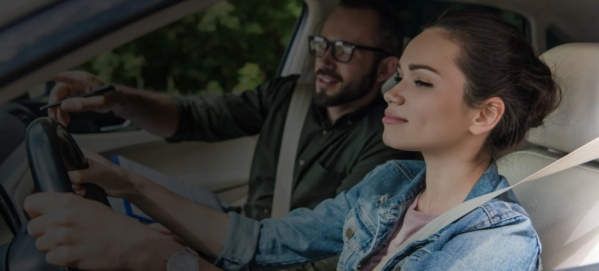 Учениця та інструктор під час практичного заняття з водіння в автомобілі