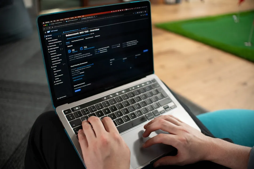 На зображенні показано руки молодої людини європейської зовнішності, яка працює за срібним ноутбуком