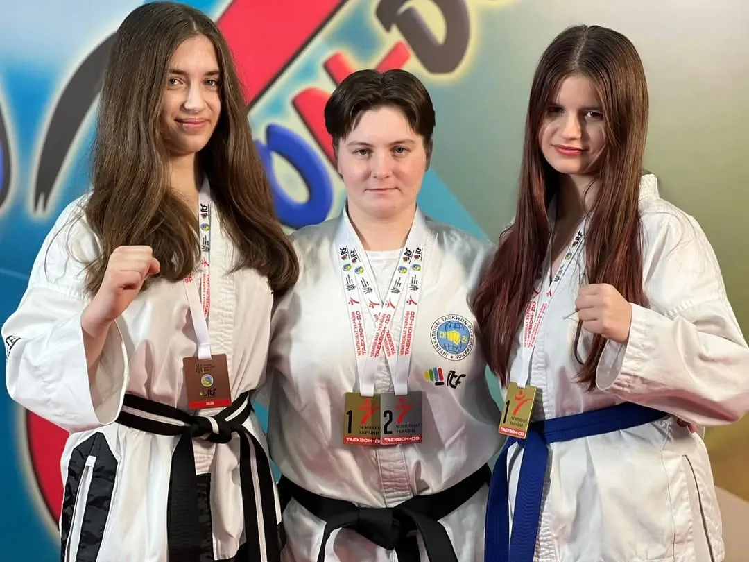 Три спортсменки з медалями на подіумі після змагань з таеквон-до