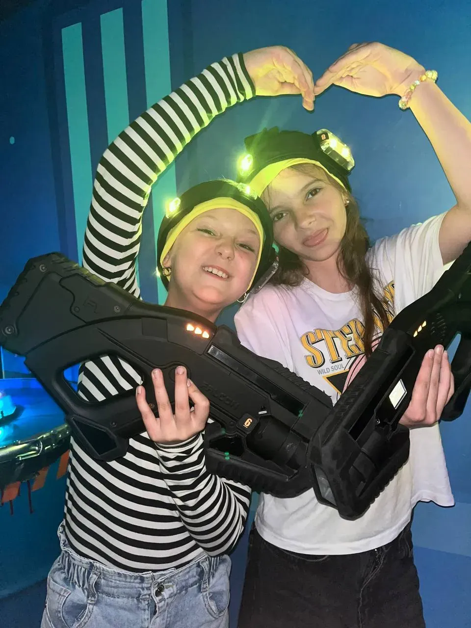 Дві дівчини з лазертаг обладнанням посміхаються в клубі Авалон