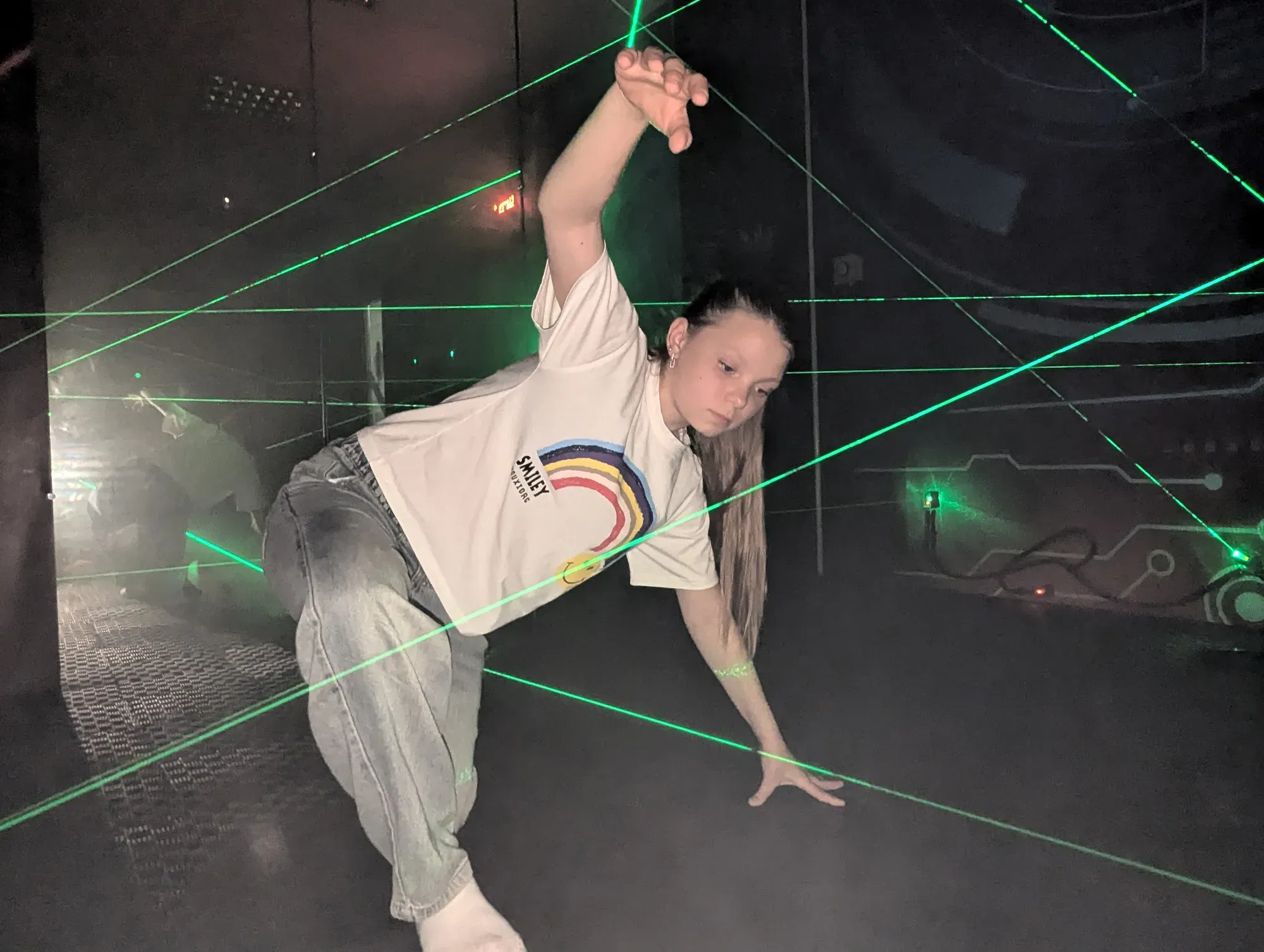 Дитина проходить лазерний лабіринт з зеленими лазерними променями