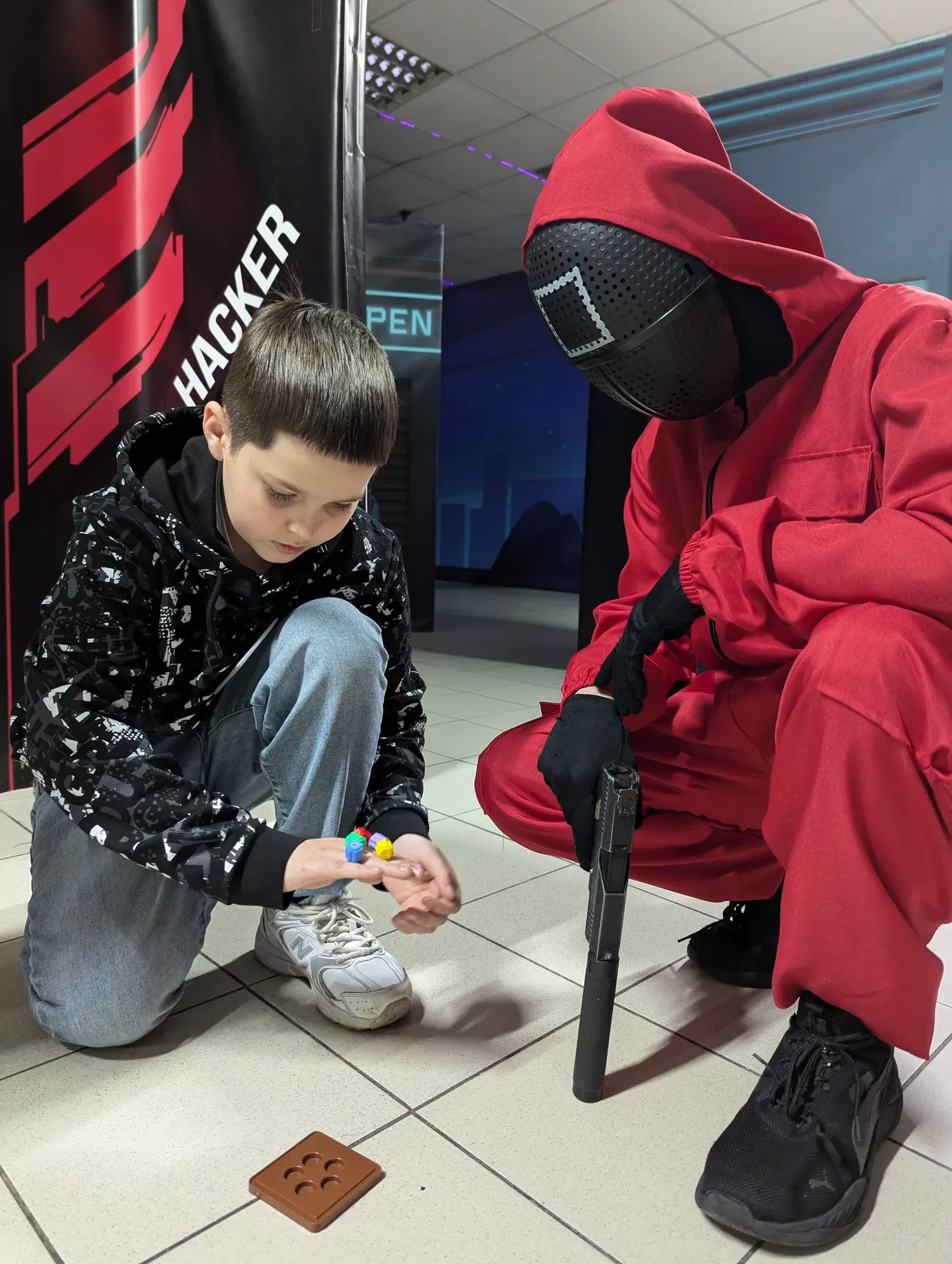 Дитина грає з персонажем Гри в Кальмара у клубі Авалон