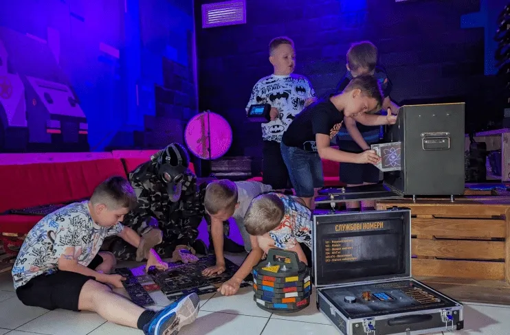 Діти з персонажем у військовій екіпіровці під час гри в клубі Авалон