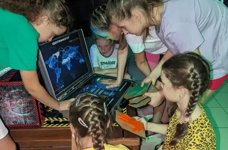 Діти розглядають лазертаг обладнання з кейса перед початком гри