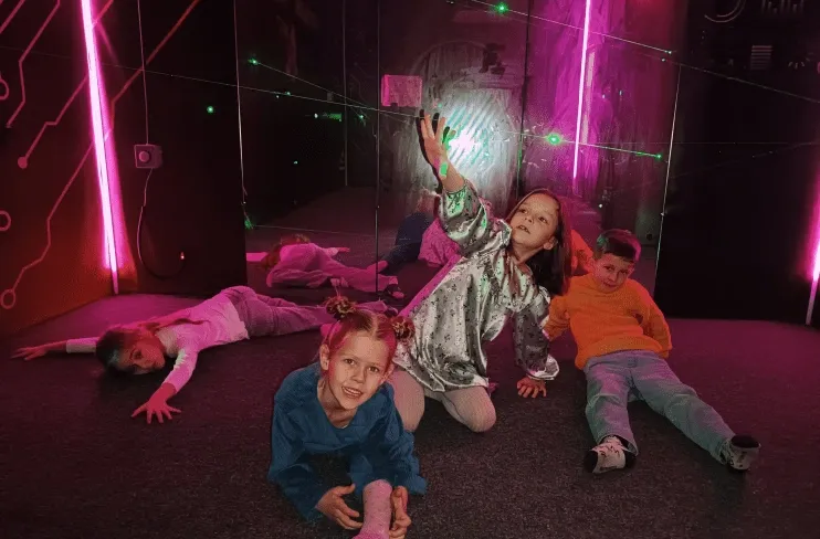 Діти веселяться на арені з фіолетовим неоновим підсвічуванням