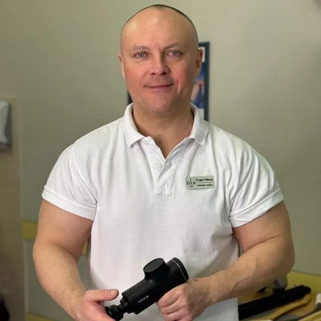 Масажист Євген з масажним пістолетом — професійне обладнання для глибокого масажу