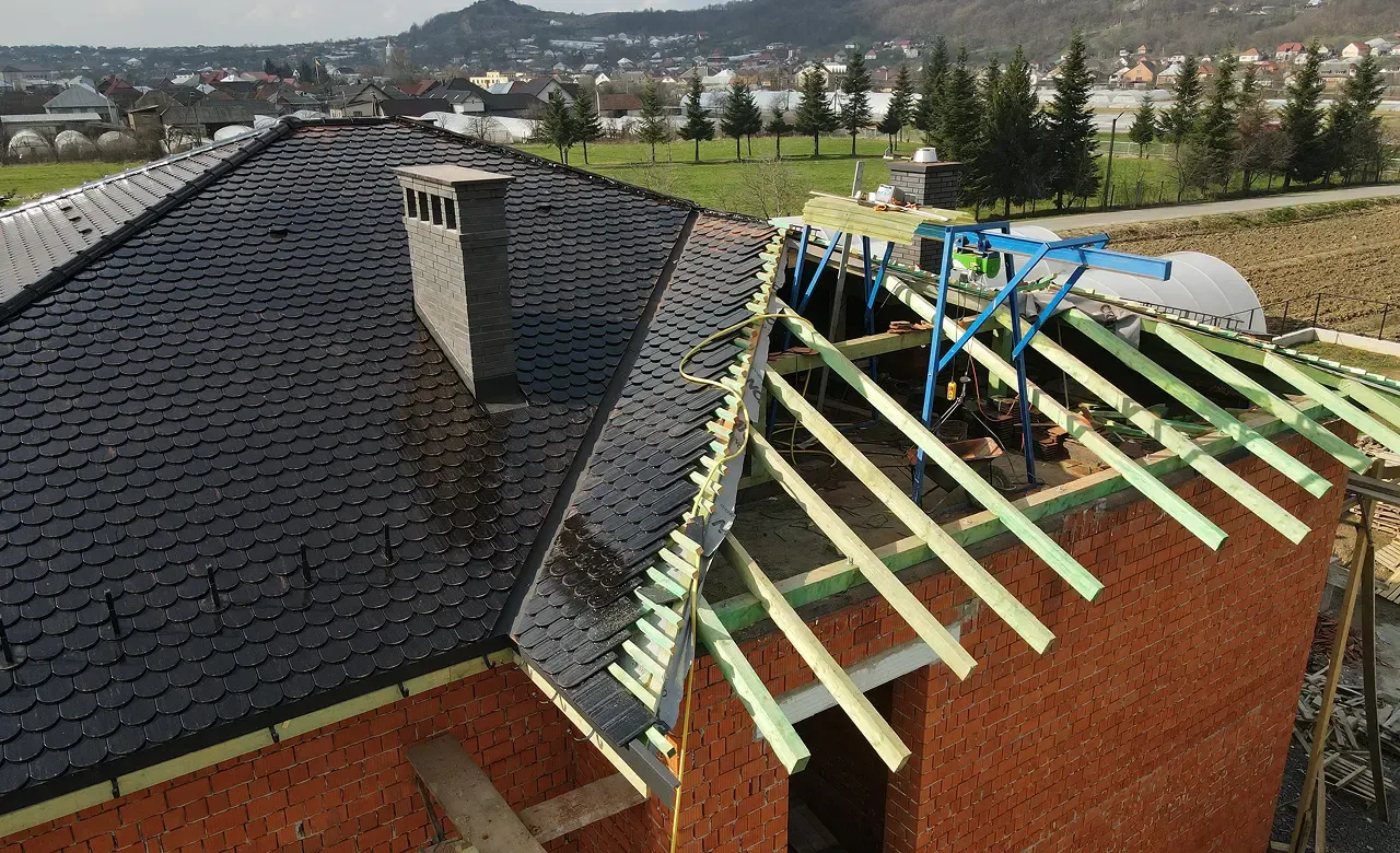 Будівництво даху з керамічної черепиці — стропильна система та темна черепиця на приватному будинку